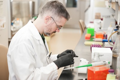 Image of Laboratory worker studying sample in a vial