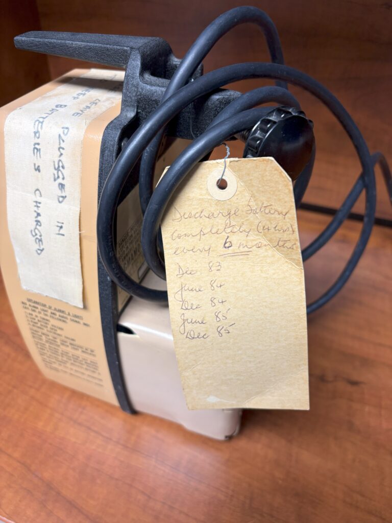A large volume infusion pump from the mid-1980s has a tag attached used for preventative maintenance tracking