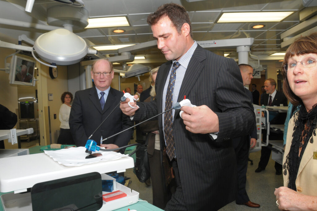 Donor Eric Lindros (right) tests some of the equipment at the opening of the Lindros Legacy Research building in 2010, as then-LHSC Board Chair, Peter Johnson looks on.