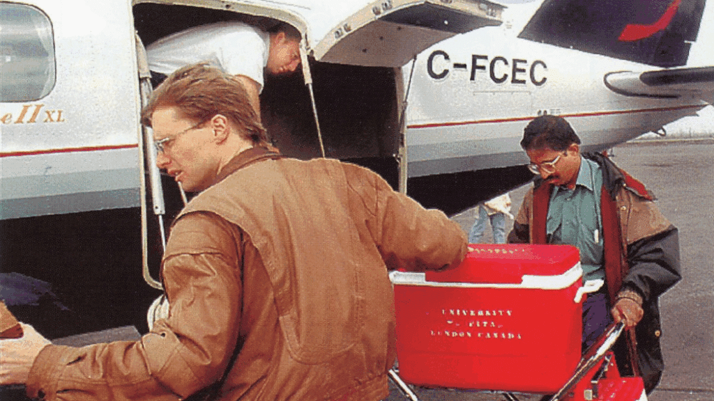 Surgeons Dr. Dave Bigam and Dr. Nagappan Kumar transport the cooler containing the liver and small bowel onto a plane headed back to London, Ontario in the 1990s.