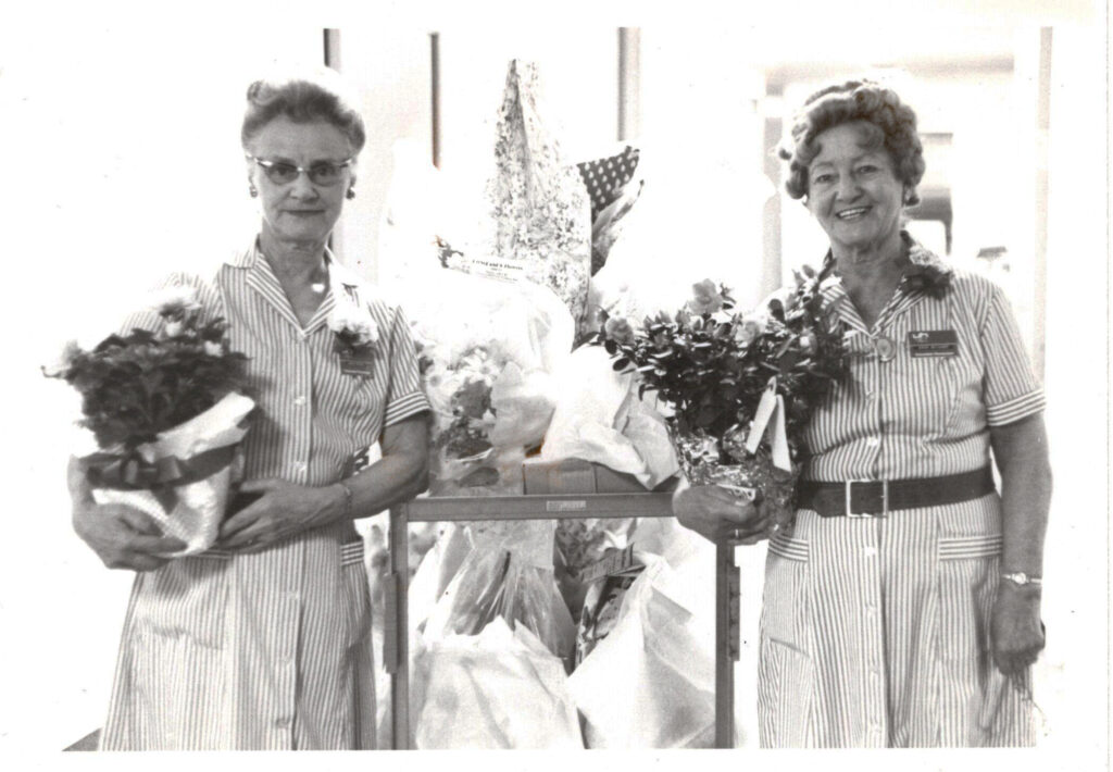 Two volunteers at University Hospital wearing the original volunteer attire.