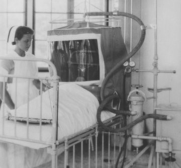 Nurse attending to a patient in an oxygen tent