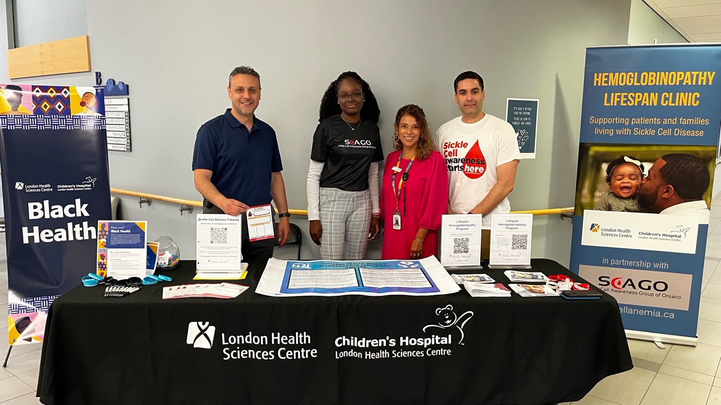 Team members at a display table in Victoria Hospital and Children's Hospital's B Atrium to recognize Sickle Cell Awareness Day.