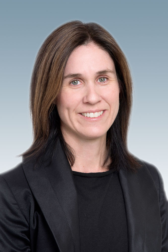 Professional headshot of woman with shoulder length dark hair, wearing black, and smiling at the camera.