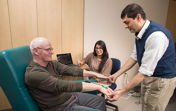 Dr. Mandar Jog pictured using sensors on his seated patient.