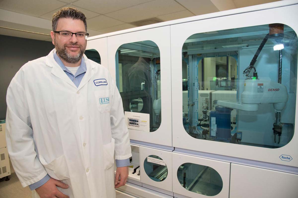 Rick Ermacora, Core Lab Coordinator, standing beside the automated storage unit in the Core Laboratory at LHSC.