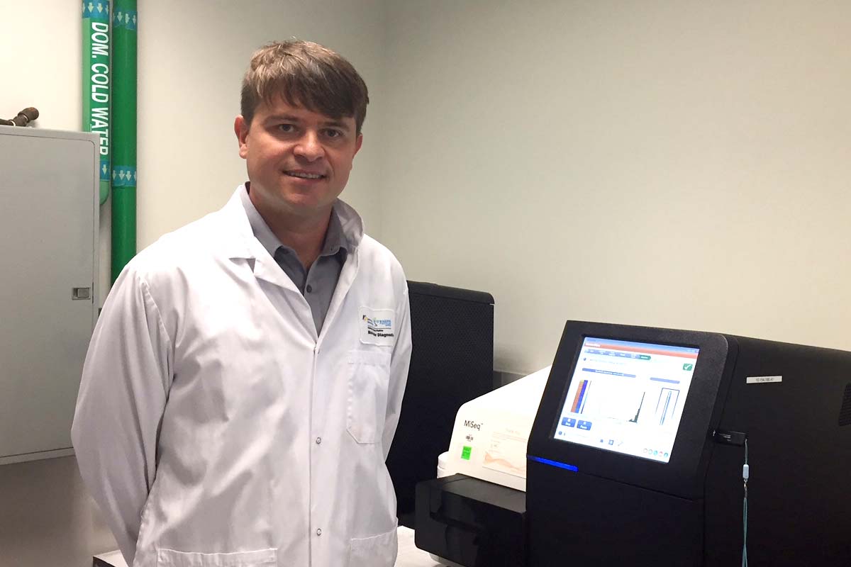 Researcher standing beside testing equipment