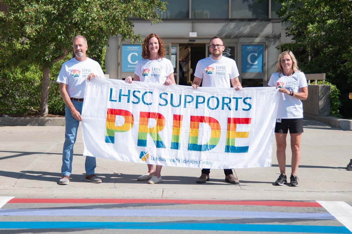 Four people from LHSC holding a sign that says “LHSC supports pride.”