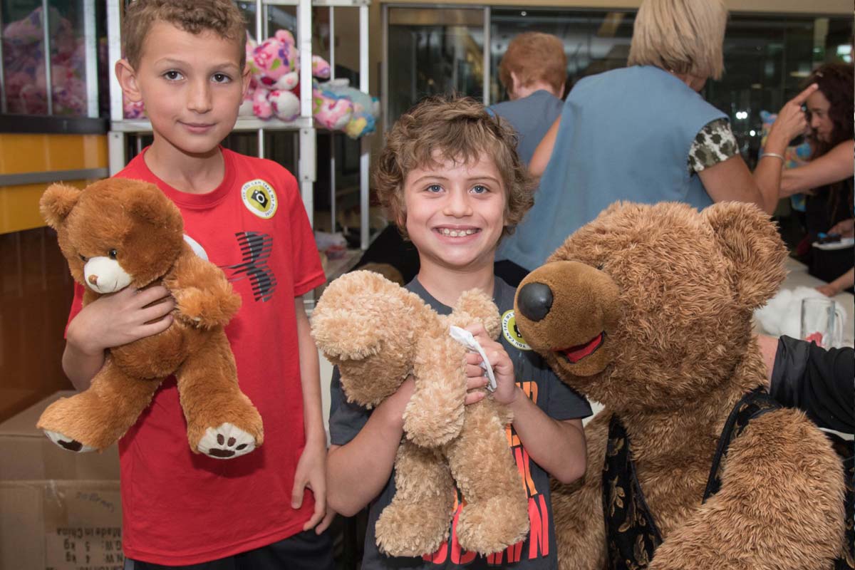 Two young boys holding teddy bears.