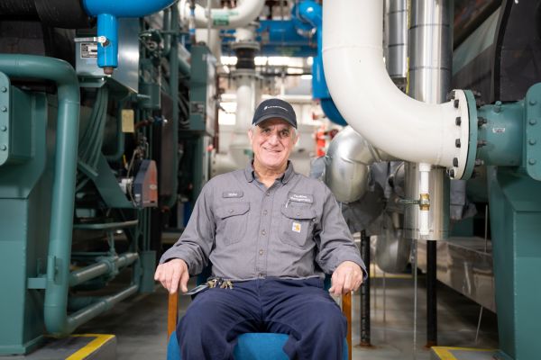 Walter sits in front of piping infrastructure. 
