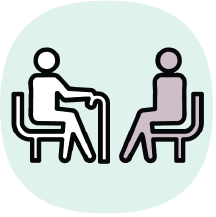 Icon of two people, one with a cane and one without, sitting on chairs facing one another. 