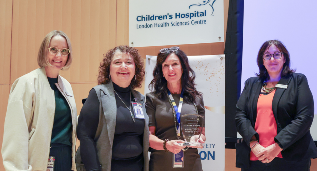 People stand holding award smiling