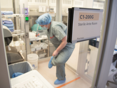 person putting on personal protective equipment in sterile ante room