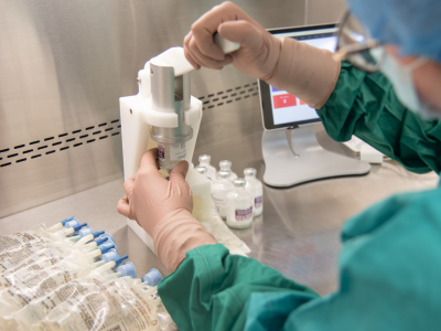 technician using machine to place vial on bag
