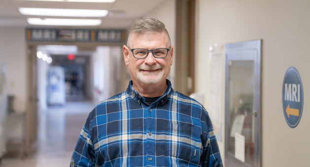 Patient Dave Evans is pictured in a hospital hallway smiling
