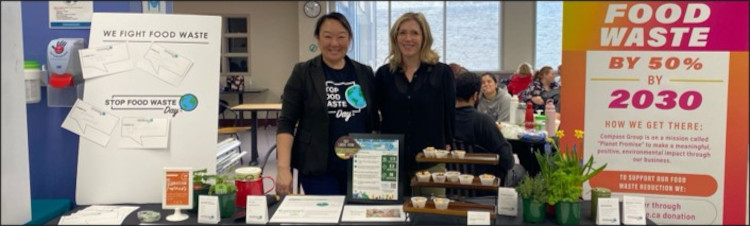Compass Group team members Jennifer Lambert, Sustainability Director (left) and Sarah Magowan, General Manager - University Hospital (right) showcasing their "Stop Food Waste Day" target at the 2024 LHSC Earth Day Fair.