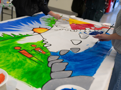 Group of people work on a painting at the Youth Indigenous Career Fair.