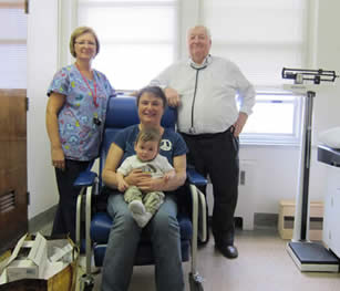 Kim Barrey holds one-year-old son Evin at a clinic visit with RN Rosemary Leitch and nephrologist Dr. Robert Lindsay.