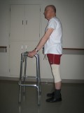 Image of a man demonstrating how to use a walker