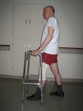 Image of a man demonstrating how to use a walker