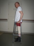 Image of a man demonstrating how to use a walker