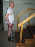 Image of a man demonstrating how to go up the stairs with two crutches