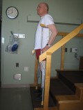 Image of a man demonstrating how to go down the stairs with two crutches