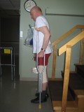 Image of a man demonstrating how to go down the stairs with two crutches