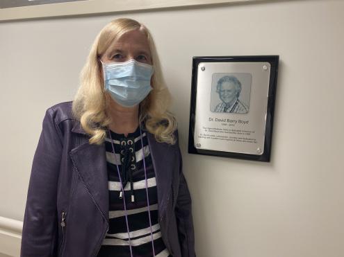 Dr. Mary Moore beside picture of Dr. David Boyd, both founders of the clinic