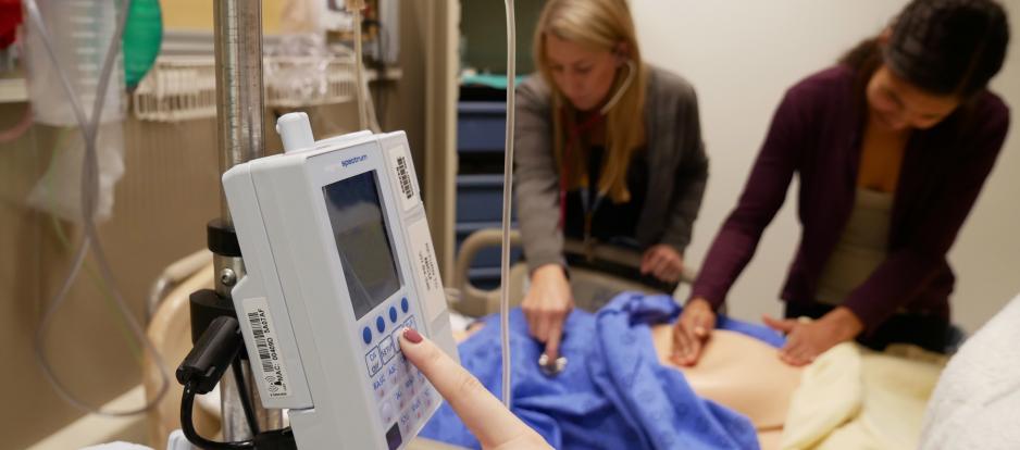 A finger presses a button on a medical device