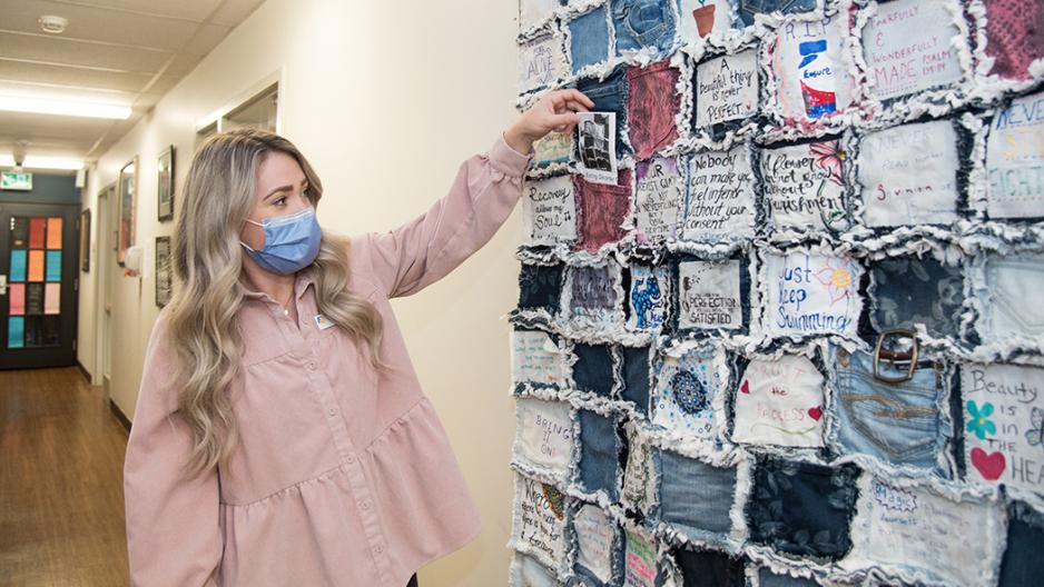Image of Image: Jenah St-Jacques, AEDS Dietitian, places a denim patch on the quilt that provides inspirational messaging to all patients.
