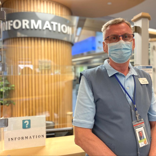 Image of volunteer standing in front of information desk