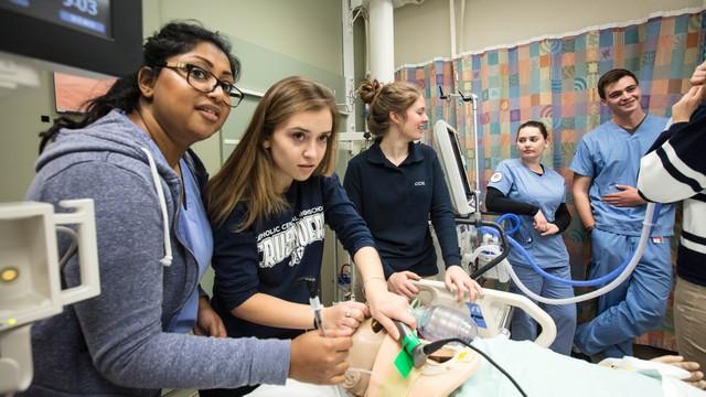 High school students intubating the trauma simulation mannequin in order to maintain the airway and respiratory function.