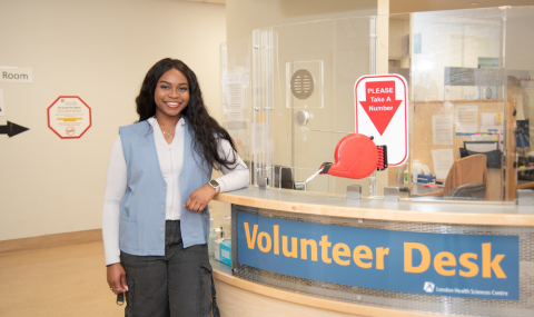 Kenny Onyeka stands at the volunteer desk in the Victoria Hospital operating room lobby.
