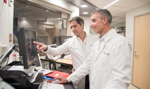 Dr. Sposato and Dr. Bagur reviewing a patient’s scan to identify the source of a blood clot that caused the stroke.