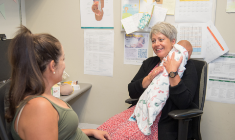 Midwife Jackie Droogers demonstrating infant feeding and burping techniques with a pregnant patient