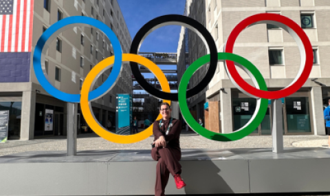 Dr. Tatiana Jevremovic sits in front of the Olympic rings at the Milan Olympic village. 