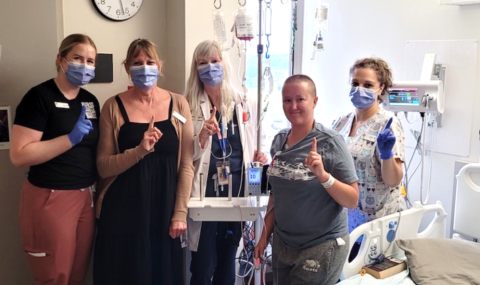 Photo of Jaci VanAltena, (patient, unmasked) with her care team in the Blood and Marrow Transplant Program (BMTP). From left: Sarah Mitchell, Registered Nurse; Lisa Bugaliski, Manager; Adrienne Fulford, Nurse Practitioner; Jaci VanAltena; and Julie Adam, Registered Nurse. 