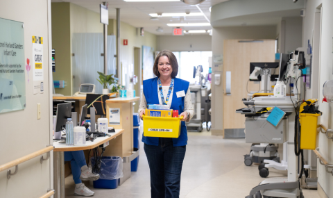 Carroll Spence, LHSC volunteer, carries a bin of toys through the Inpatient Paediatrics Unit. 