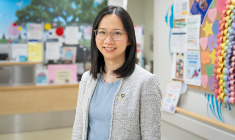 A female physician stands in a colourful hospital hallway.