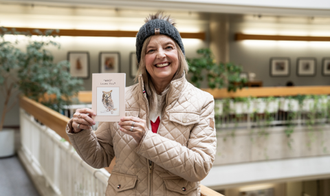 Ruth Campbell standing in LHSC atrium holding a plaque. 