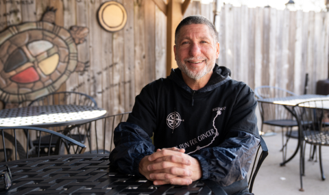 Samm Simon sitting at a table with his hands crossed.