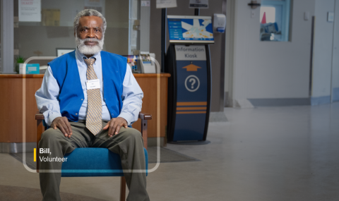 A man sits in a blue chair.