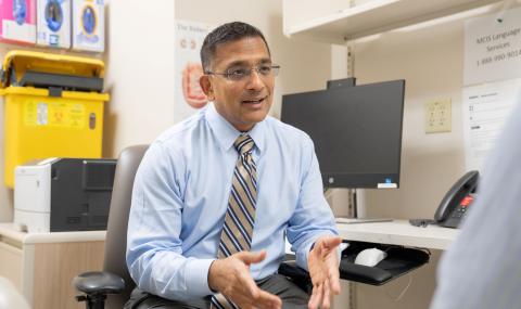 Dr. Amit Garg speaks with a patient during a consultation in a clinical examination room.