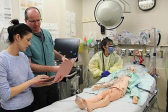 A team at the centre practices with a dummy on a hospital bed