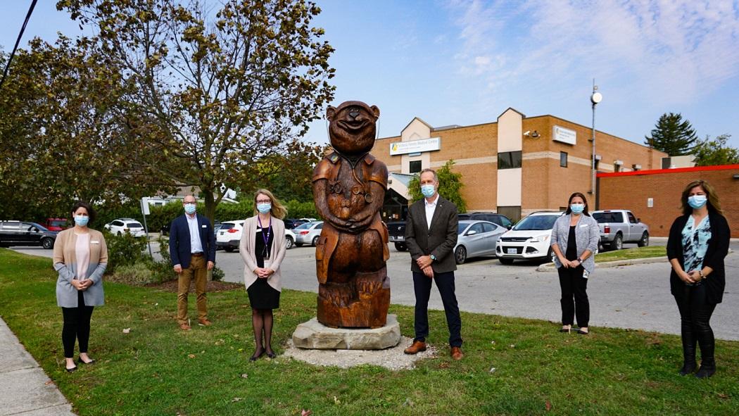 Posing with the new Dr. Tree-age sculpture outside of the Victoria Family Medical Centre are, from left: Erin Chapman, VFMC Medical Secretary; Tim Rice, Director, Medicine and Family Medicine at Victoria Hospital; Dr. Stacey Valiquet, VFMC Medical Director; Dr. Paul Woods, LHSC President and CEO; Kim Farrow, Operations Manager, Medicine Ambulatory Care; and Amanda Grant, VFMC Medical Secretary.