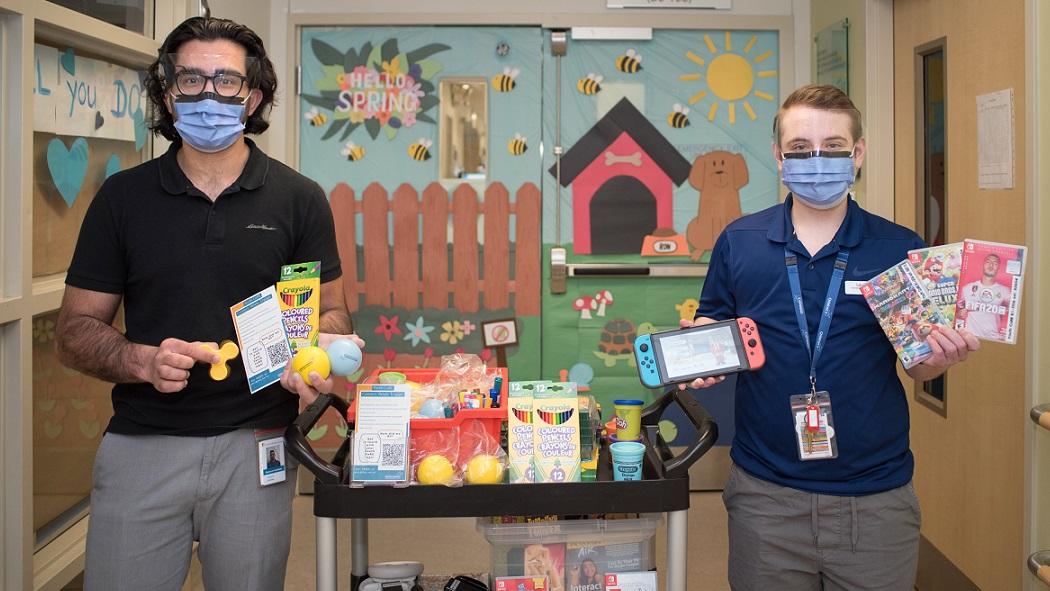 Youth CoRE facilitators, Hashir Imtiaz and Levv Shatil display the cart they take on visits with patients