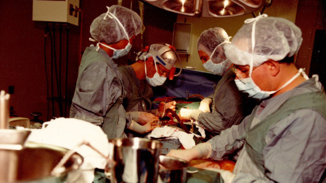 Dr. Neil McKenzie and his team perform surgery in 1980s.