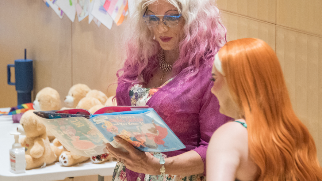 Drag Queens Mz. Affra-Tighty and Lavender Skyes reading during Drag Storytime at Children's Hospital.