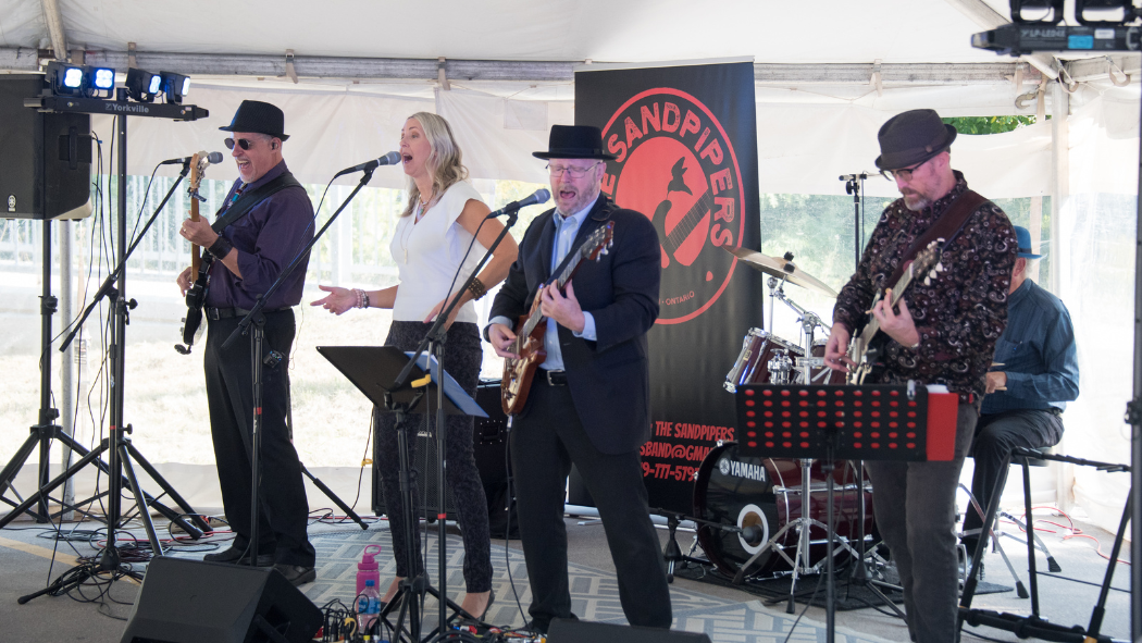 The Sandpipers playing classic rock tunes under the UH 50 celebration tent.